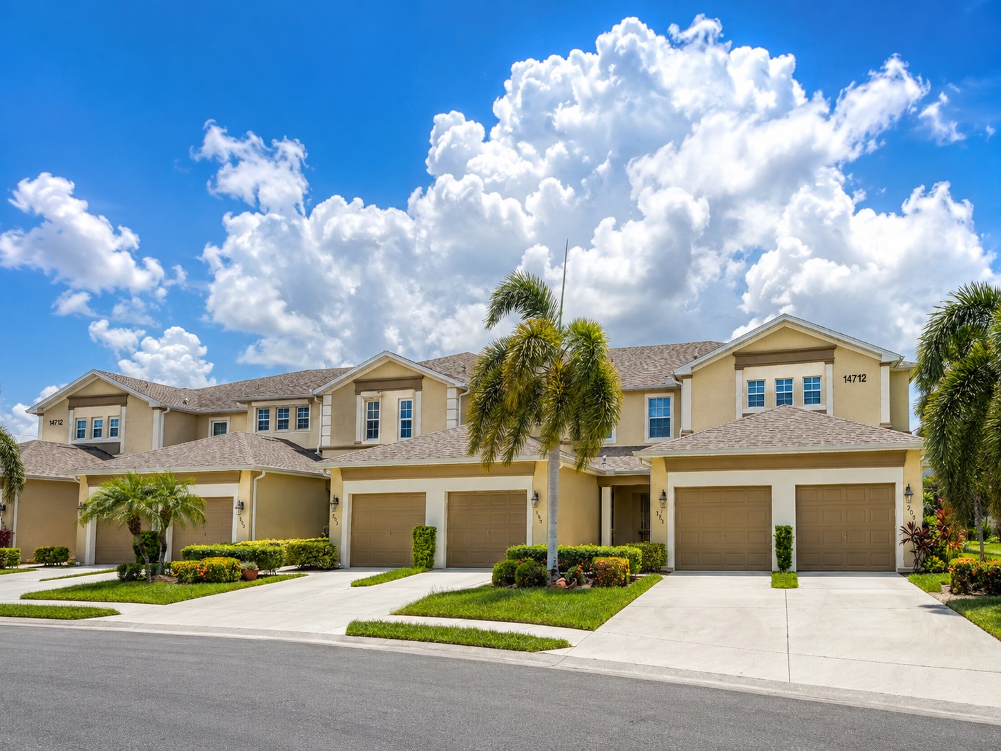 Exterior of the well-kept townhome with garage and tropical planting